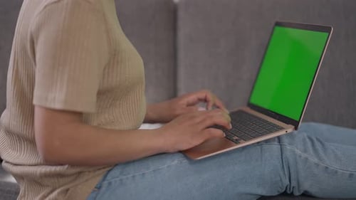 Side View of Unrecognizable African American Woman Typing on Laptop Keyboard with Green Screen