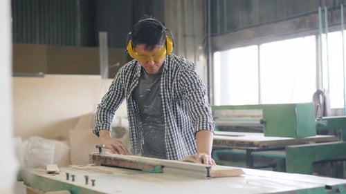Man Using Table Saw in Woodworking Shop