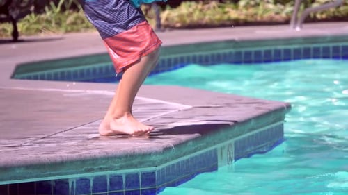 A boy plays in a pool at a hotel resort.