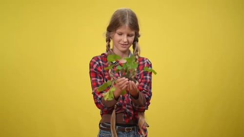 Medium Shot Smiling Teenage Ecoactivist Holding Green Herb Looking at Camera