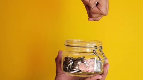 Adding Coins to Jar for Savings