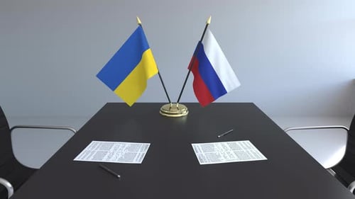 Ukraine and Russia Flags Waving on Meeting Table