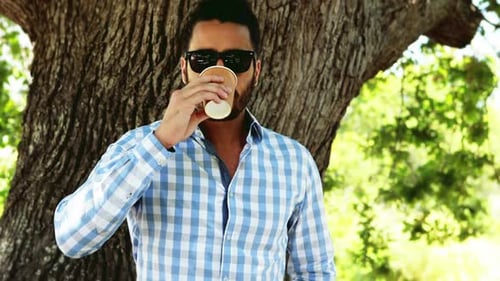 Man having coffee in park 4k