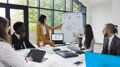 Business Meeting with Charts and Laptops