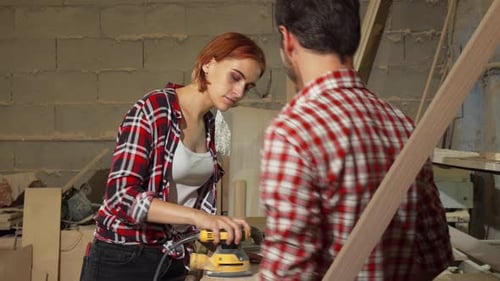Two Carpenters Working on Wood Plank at the Workshop