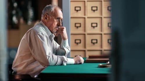 Sad Grandfather Thinking About Retirement Solitude Health Problem Sitting at Table in Home Library