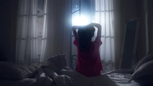 Woman Waking up and Stretching in Bedroom