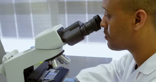 Scientist looking through microscope