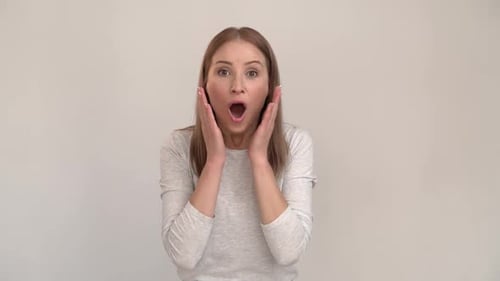 Portrait view of astonished woman standing with mouth open in surprise, has shocked expression