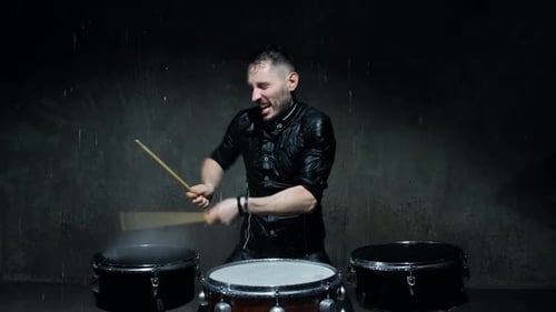 Energetic Drummer Plays in the Rain at Night