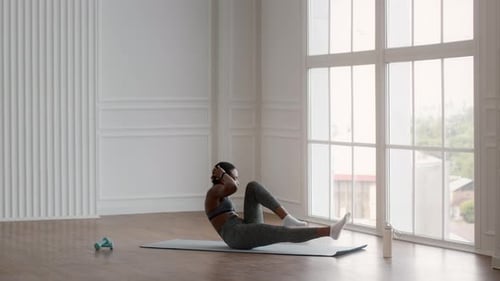Woman Doing Crunches on Mat in Bright Room