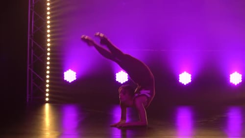 A Flexible Professional Female Athlete Performs Complex Acrobatic Elements of Rhythmic Gymnastics