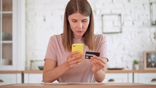 Woman Uses Phone and Credit Card for Online Banking