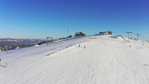 Old Ski Station on a Snowy Mountain Slope with a Lot of People on Skis and Snowboards