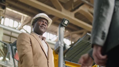 African American Factory Engineer Giving Handshake to Colleague