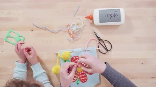 Flat lay. Little girl learning how to sew with her mother at the craft table.