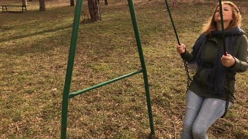 Une femme blonde au ralenti se balance dans le parc Vidéo HD 1920X1080 - Femme caucasienne se relaxant sur une chaîne