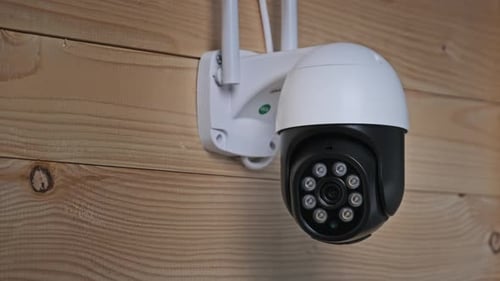Modern Security Camera Mounted on a Wooden Wall