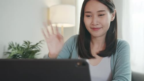 Woman Video Chatting Waving at Laptop in Bright Home
