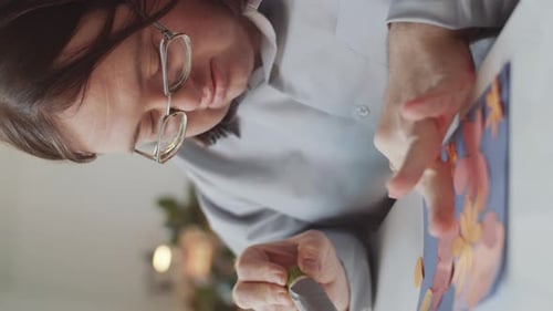 Woman Crafts Paper Flower Card at Home
