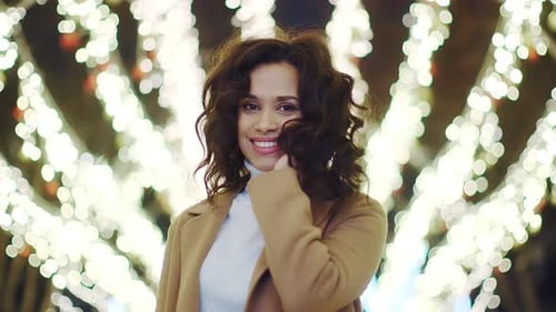 Attractive Woman Smiling in Front of Holiday Lights