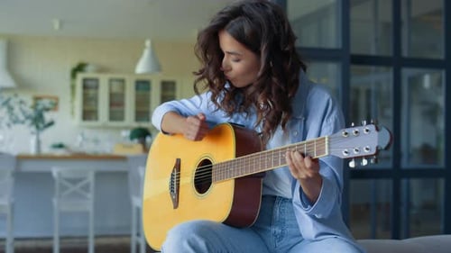 Woman Plays Guitar at Home