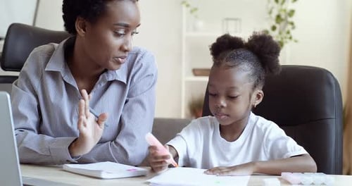 African Ethnic Mom Teaching Helping Learning Distance Daughter Child to Do Homework