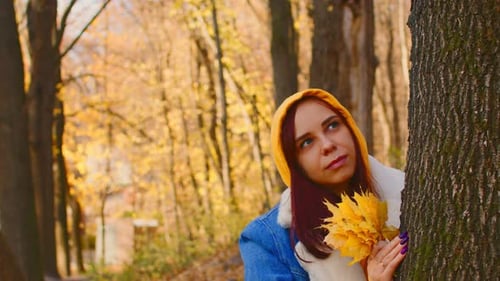 Young Woman Near Tree in Autumn Forest