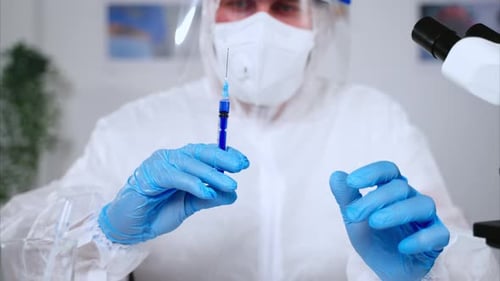 Medical Professional Holding Syringe in Laboratory