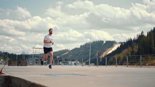 Young man running fast and intense in forest