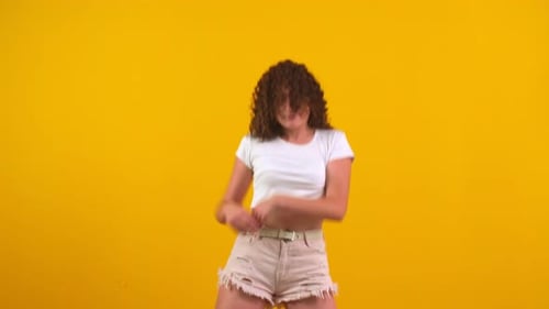 Woman Dancing Energetically on Yellow Background