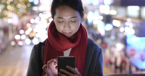 Woman use of mobile phone in city over traffic road background