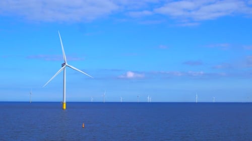 Windmills generating green energy at the sea in 4K