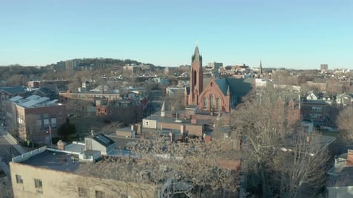 Aerial Drone Shot Ascending Past a Street and Church Steeple in Suburban Boston