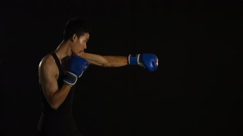 Man in Blue Boxing Gloves Practices Punches