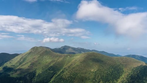 Rolling Green Mountains Under Blue Sky and Clouds