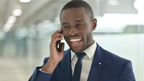 Young Adult Excited About Phone Conversation in Office