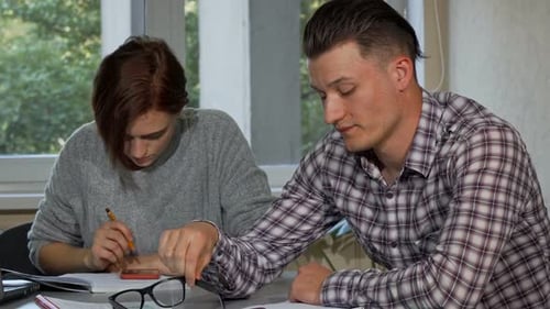 Male Student Taking Off His Glasses Looking Tired While Studying