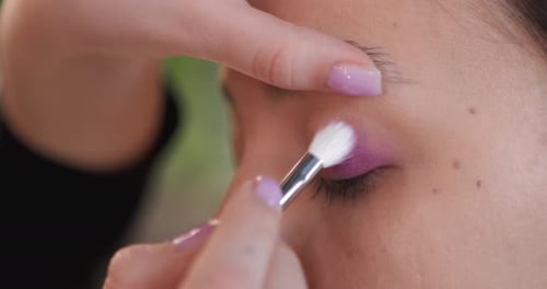 Woman Receives Purple Eyeshadow Application Close Up