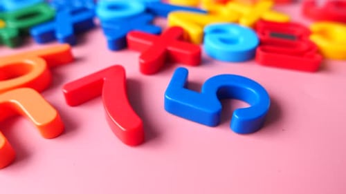 Colorful Plastic Letters on Pink Background, Close Up