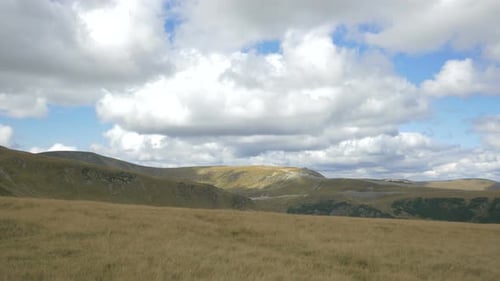 Scenic Landscape of Rolling Hills and Cloudy Skies