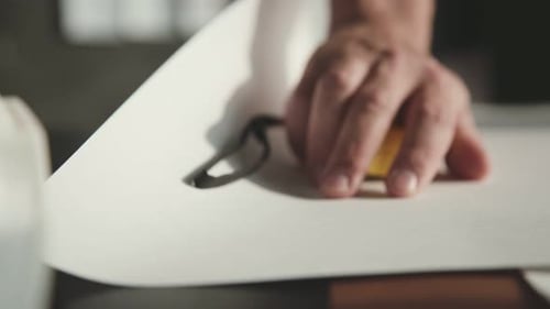 Male Hands Unfold the Roll with Drawings. Process of Unfolding Paper