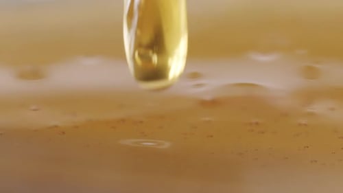 A drop of honey dripping from the top of the frame into an endless surface of honey. Slow and satisf