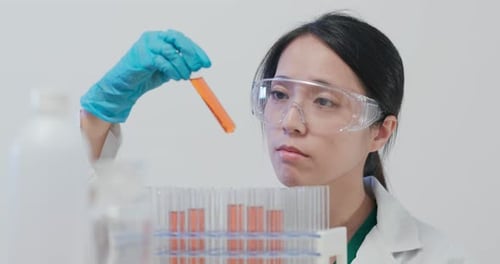 Scientist Analyzing Test Tube in Bright Lab