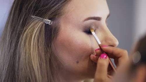 Woman Getting Eye Makeup Applied with Brush