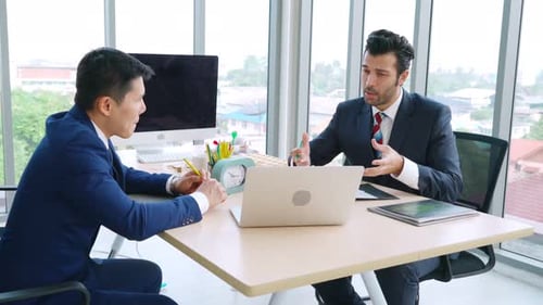 Two Business People Talk Project Strategy at Office