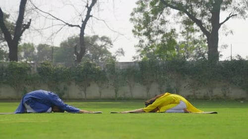 Pose estendida de ioga infantil ou Prasarita Balasana está sendo feito por um casal indiano em uma roupa indiana