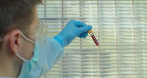 Scientist Examines Blood Sample in Lab