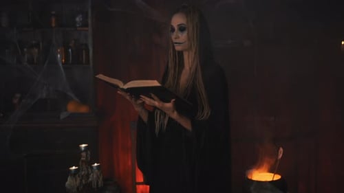 Halloween-Hexe verwendet Zauberbuch und Kessel und bereitet Gift oder Liebestrank zu
