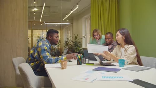 Multiethnic Coworkers Discussing Document in Office